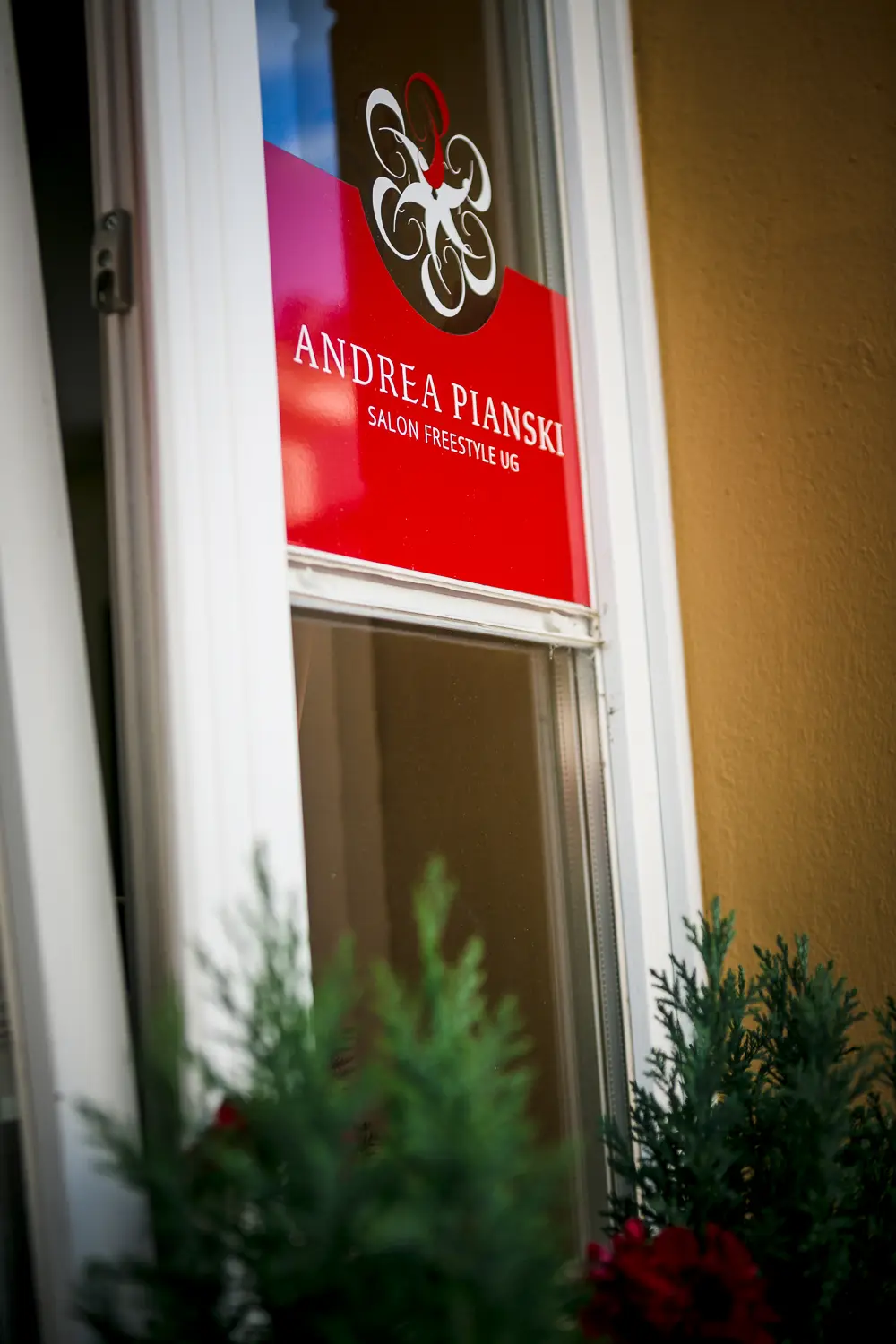 Andrea Pianski-Salon Freestyle UG – Spiegelung einer Frau in der Glastür des Salons